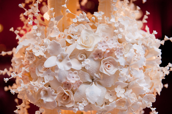 details of ivory floral decorations on the top of a wedding cake - photo by Houston based wedding photographer Adam Nyholt 